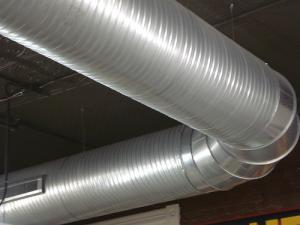 HVAC contractors install a new air duct in a commercial building